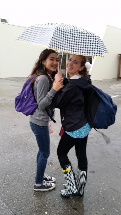 Two students take cover from the stormy El Nino weather. 