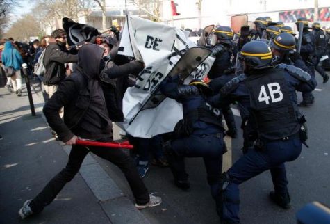 (Credit: Michel Euler) A young individual in a scuffle with police during a public demonstration to protest labor reforms. 