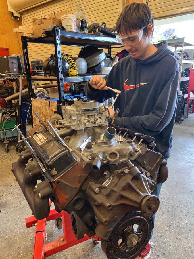 Joseph Newman (9) takes off the rocker-arms of an engine.