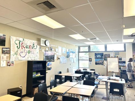 An inside look into Mrs. Peoples french class, featuring several posters and a collaborative desk setup.
