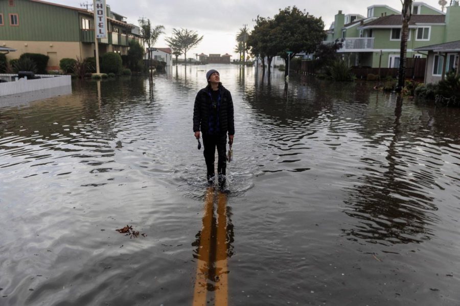 A resident walks along a flooded street, after atmospheric river rainstorms slammed northern California, in the coastal town of Aptos, U.S., January 5, 2023. Courtesy of Carlos Barria.